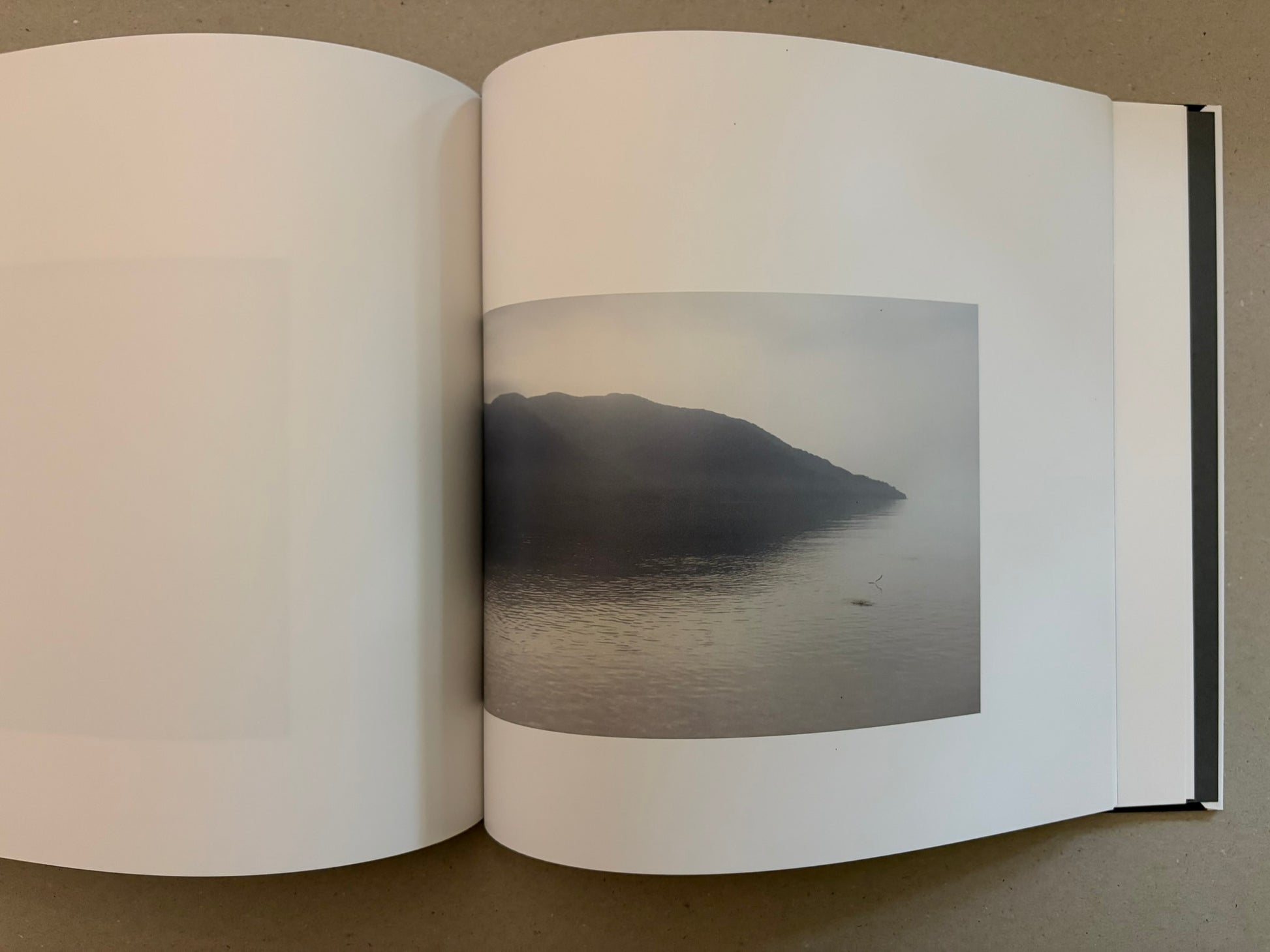 Close view of the open book’s gutter and stacked page edges, showing the black cover beneath.