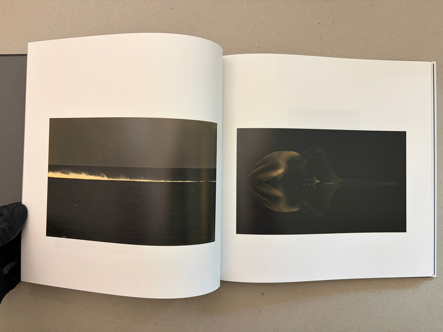 Open Kurayami spread with a wide dark seascape on the left and a dim mirrored figure on the right.