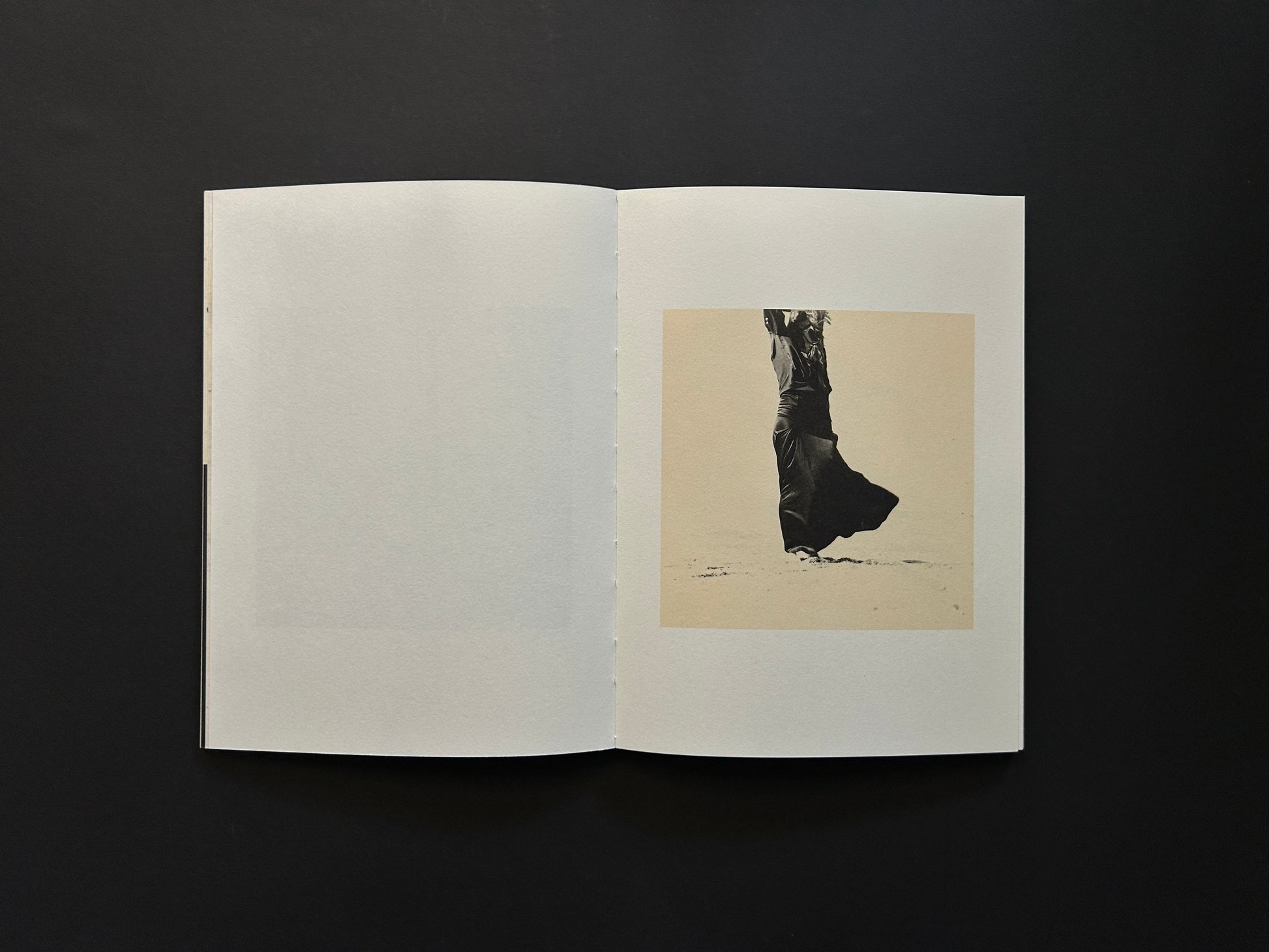 Open spread from Lejos De La Tierra showing a small black-and-white figure photograph on the right page