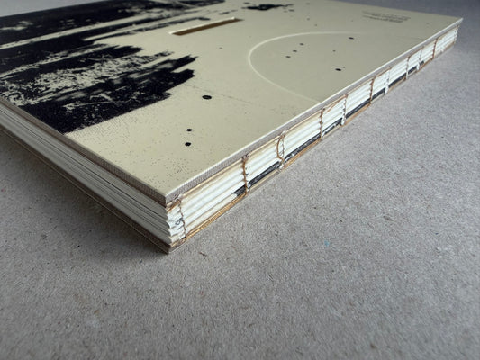 Lejos De La Tierra by Irene Zottola, angled view of the book’s cover and stitched spine