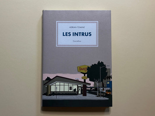 Les Intrus by Adrian Tomine, front cover with a grey jacket and a diner scene at the bottom