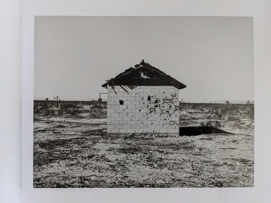 Photograph of a small cinder block desert structure from "Message from the Exterior"