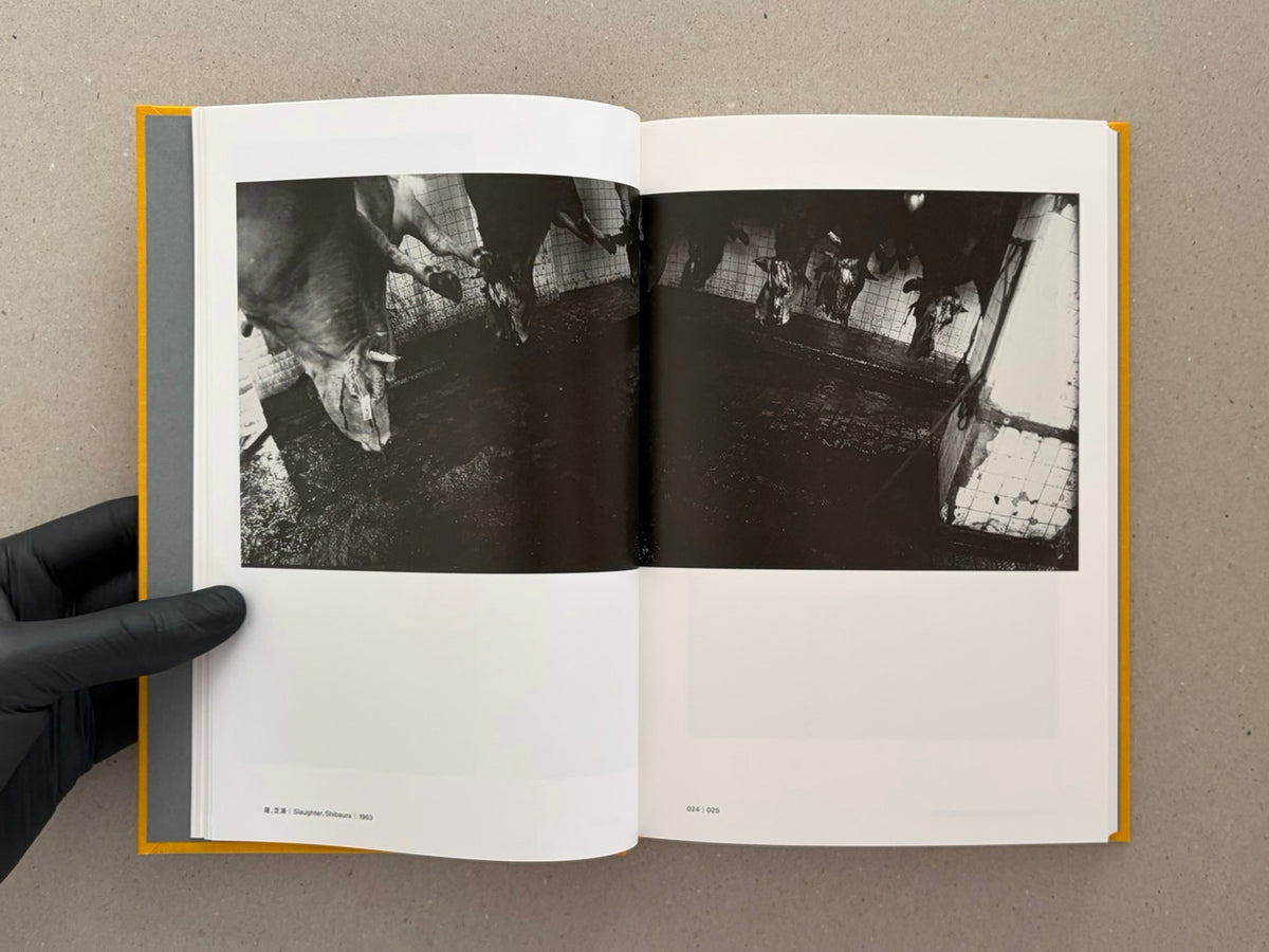 Open spread from Masahisa Fukase 1961–1991 Retrospective showing a black-and-white photograph of hanging cattle in a tiled slaughterhouse, with page numbers 024 and 025 visible.