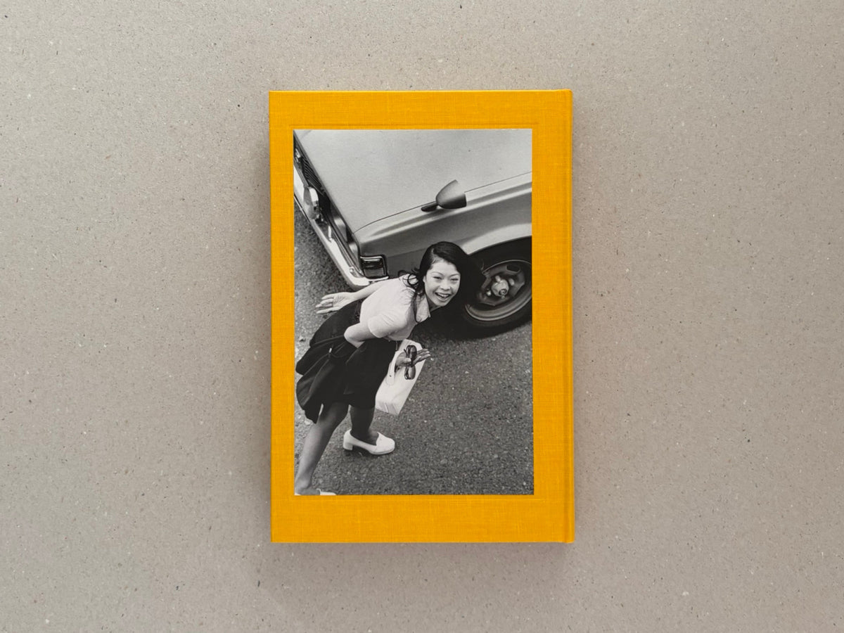 Masahisa Fukase 1961–1991 Retrospective, front cover on a grey surface, showing a black-and-white photograph framed by a yellow border.