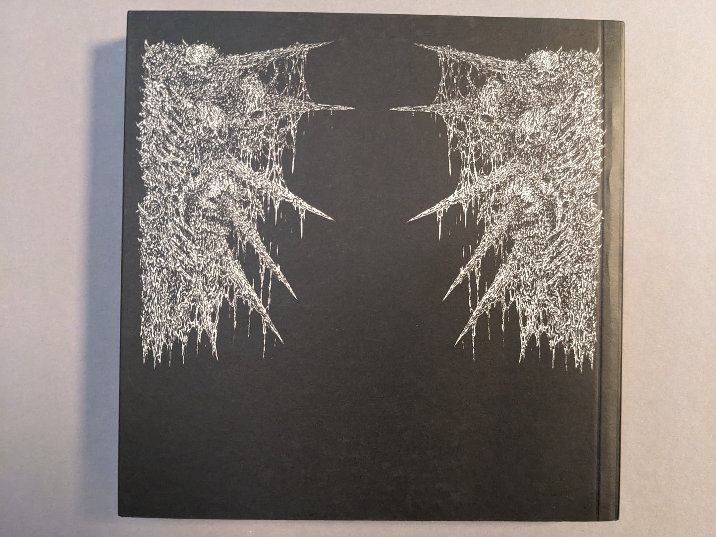 Back cover of Manifester Monsters art book by Mat Brinkman with silver printed artwork