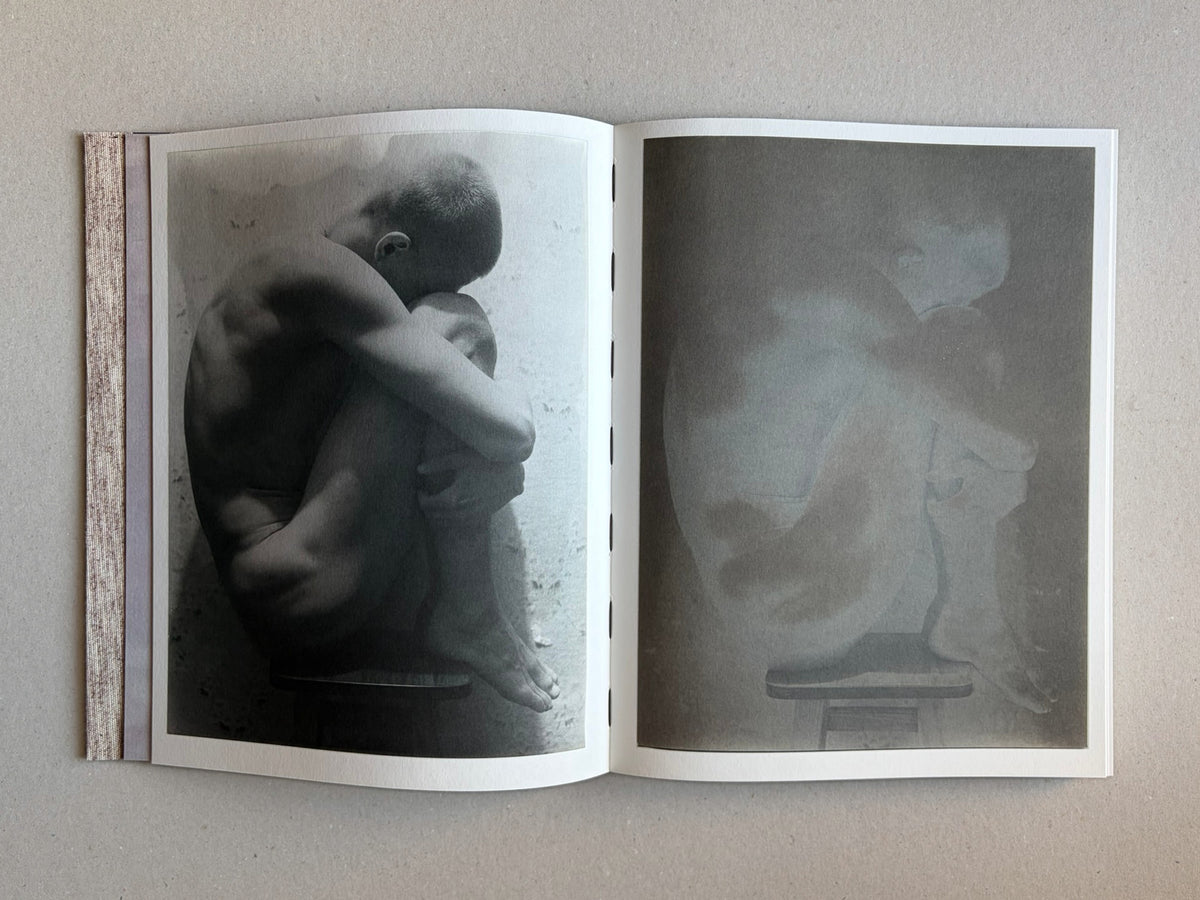 Open spread of Materia by Vic Bakin, showing two faded monochrome photographs of a seated nude figure on aged paper.