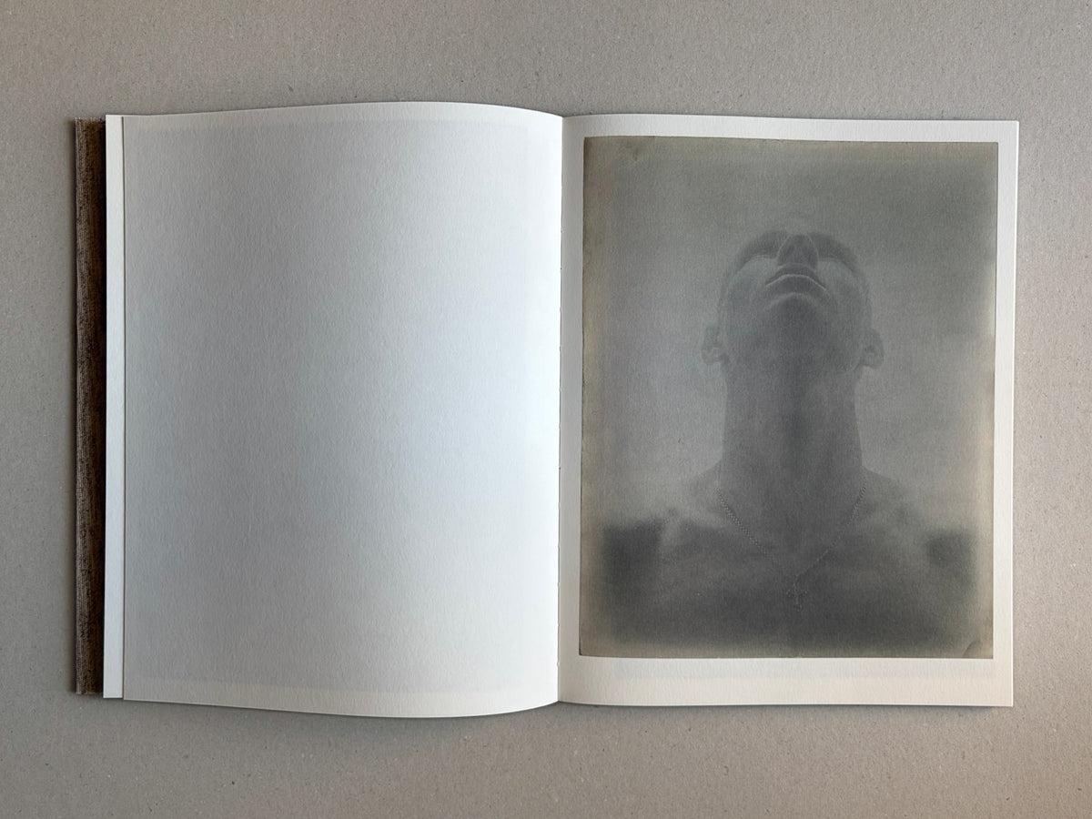 Materia by Vic Bakin, open photobook spread with a faded portrait print on the right-hand page