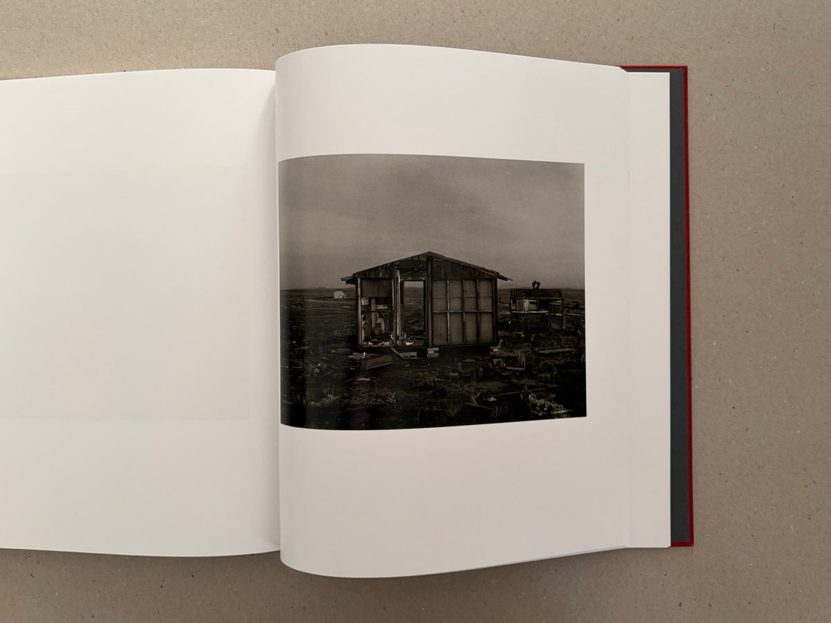 Open spread of Message from the Exterior by Mark Ruwedel, showing a black-and-white photograph of a small abandoned structure in a desert landscape.