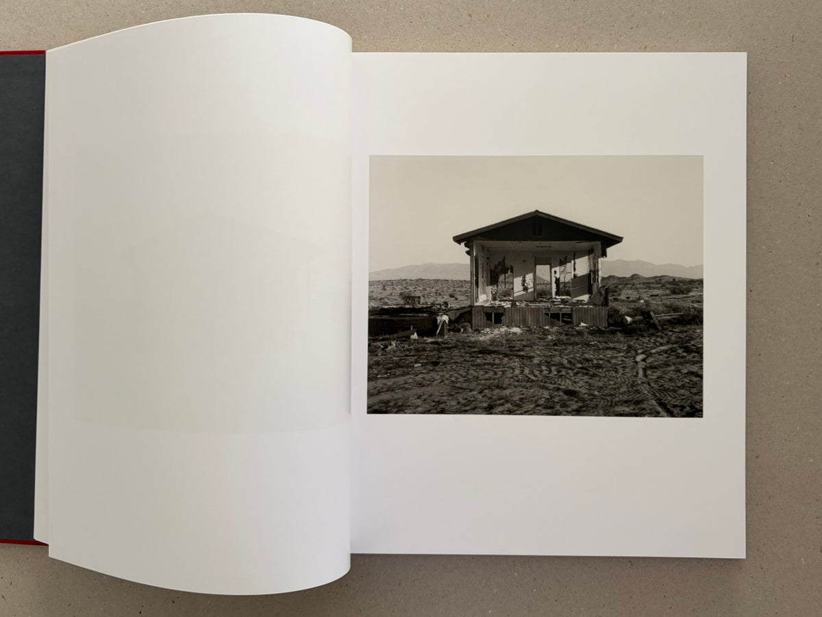 Open spread from Message from the Exterior by Mark Ruwedel, with a black-and-white photograph of a ruined desert house on the right page.