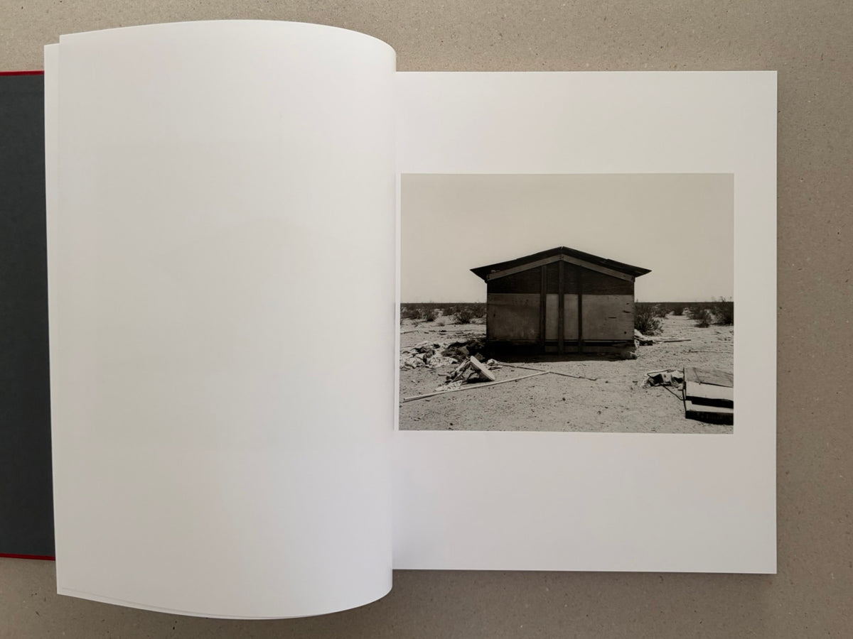 Open spread of Message from the Exterior by Mark Ruwedel, showing a small desert house photograph on the right-hand page.