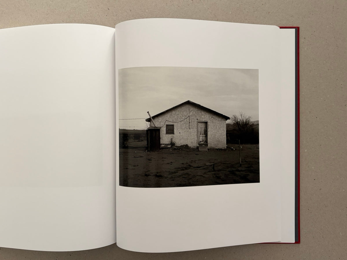 Open spread of Message from the Exterior by Mark Ruwedel, showing a small desert house photograph on the right-hand page.