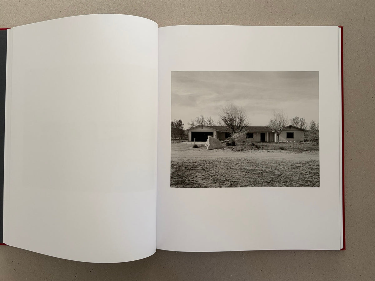 Open spread of Message from the Exterior by Mark Ruwedel, showing a black-and-white landscape photograph of a low house in a desert setting.