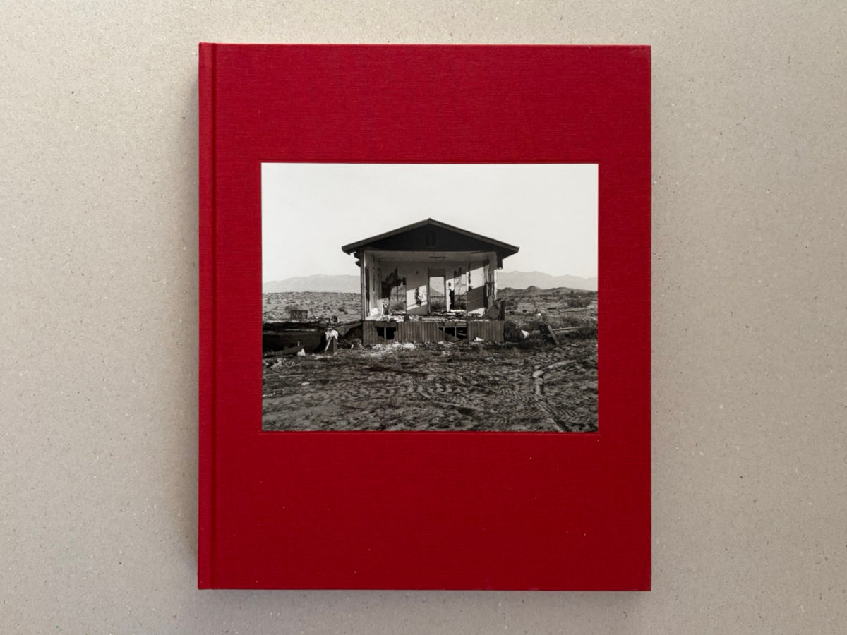 Front cover of Message from the Exterior by Mark Ruwedel, showing a black-and-white photograph of an abandoned desert house on a red clothbound hardcover.