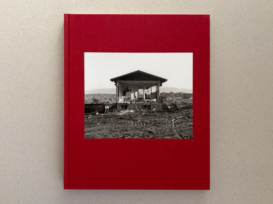Front cover of Message from the Exterior by Mark Ruwedel, showing a black-and-white photograph of an abandoned desert house on a red clothbound hardcover.