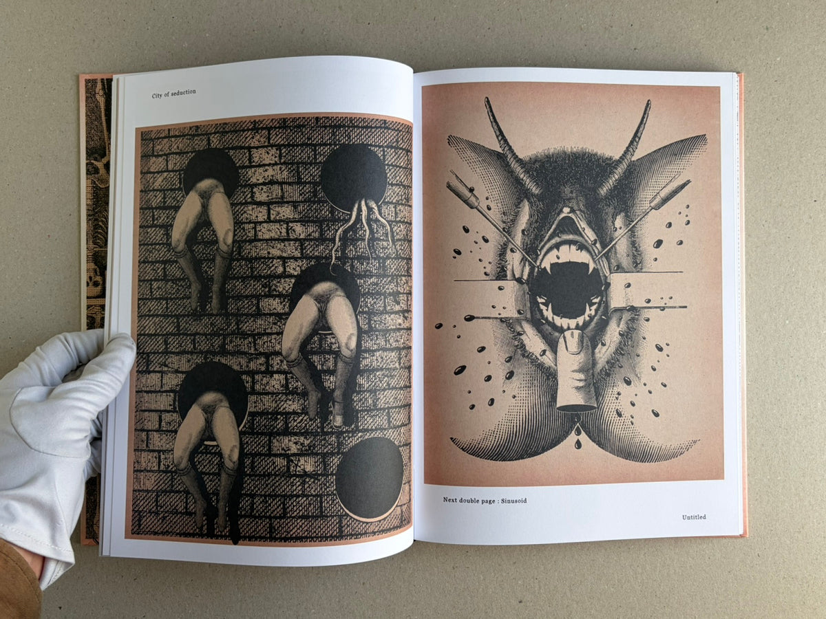 Open spread of METAFABLES: The Art of Andrew Blucha showing two surreal black-and-white illustrations, with a gloved hand holding the book at lower left.