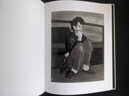 Interior photograph from Mimi Plumb’s Landfall showing a person crouching on a wooden floor in a domestic setting.