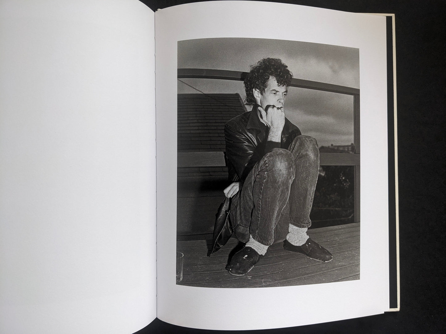 Interior photograph from Mimi Plumb’s Landfall showing a person crouching on a wooden floor in a domestic setting.