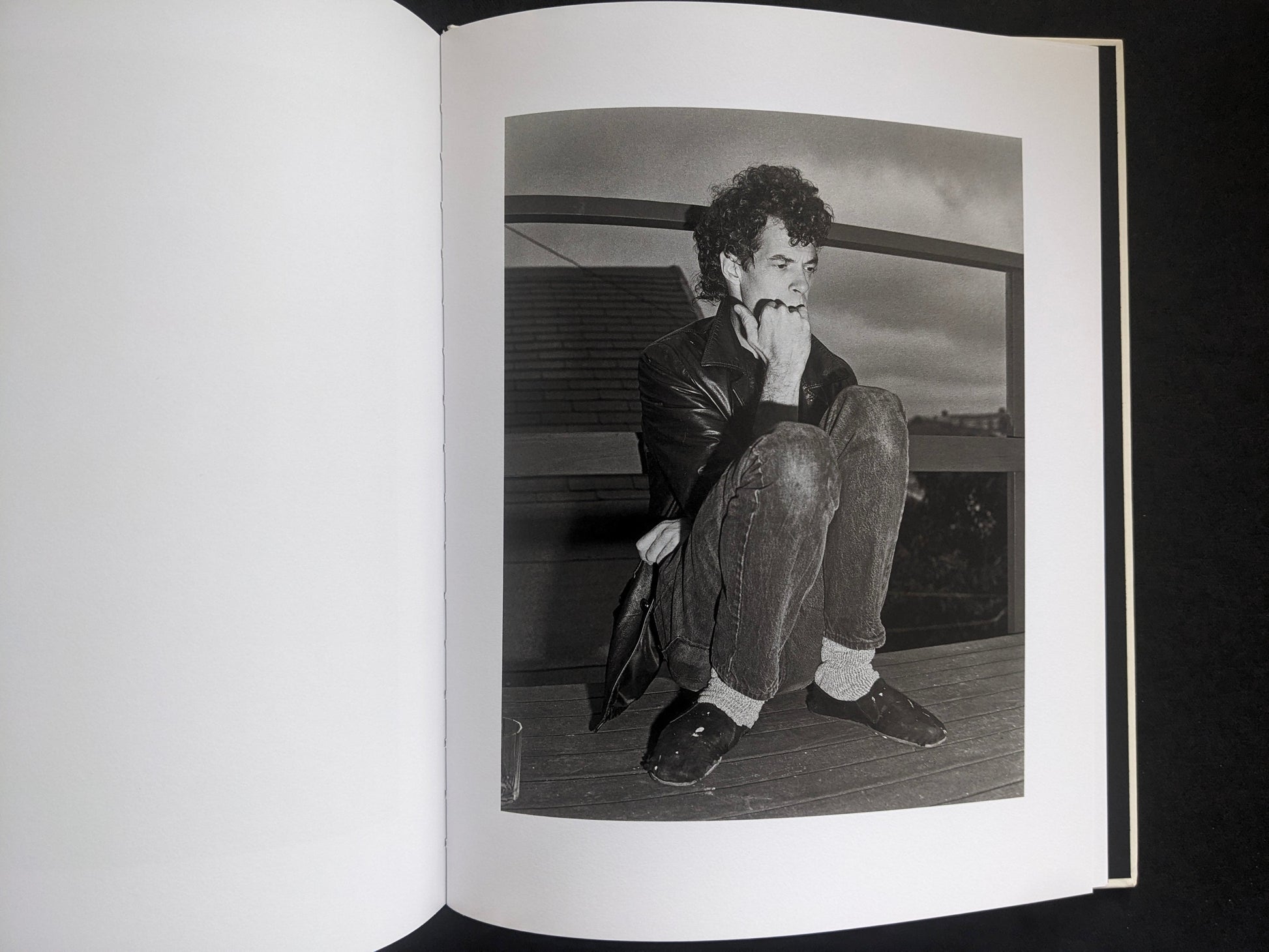 Interior photograph from Mimi Plumb’s Landfall showing a person crouching on a wooden floor in a domestic setting.