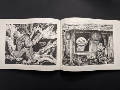 Open book displaying black and white illustrations on a dark background