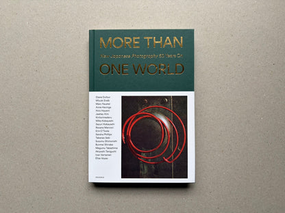 Front cover of More Than One World – New Japanese Photography 50 Years On, showing the title in gold on a green and white cover with a photograph inset below.