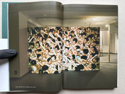 Open book spread from More Than One World – New Japanese Photography 50 Years On, showing a full-bleed crowd photograph across the left page.