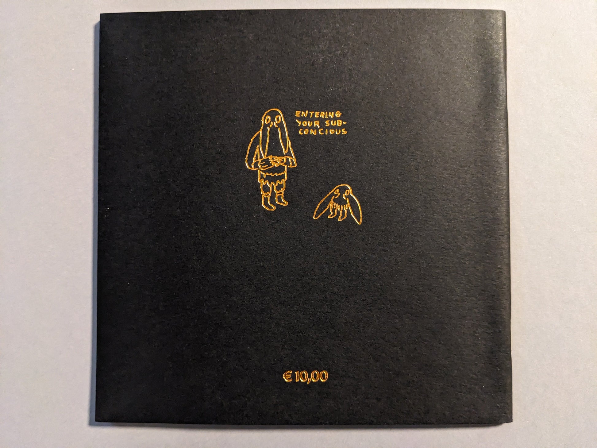 Back cover of Multiforce Shit by Mat Brinkman, bronze print on black paper