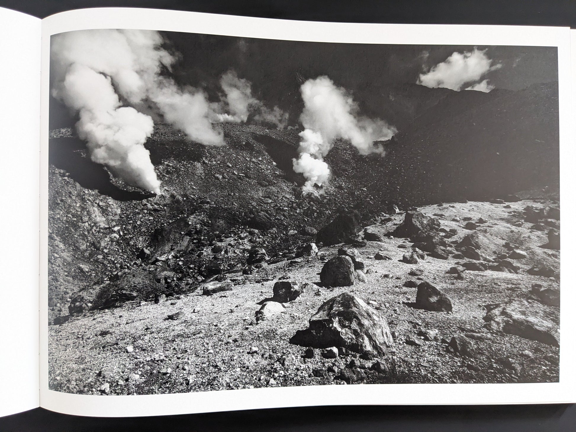 Black and white image of steaming vents in rocky terrain, New Land