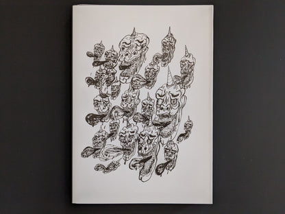 Back cover of The Life of Namazuko featuring a pattern of grotesque demon heads with horns and flowing tongues.