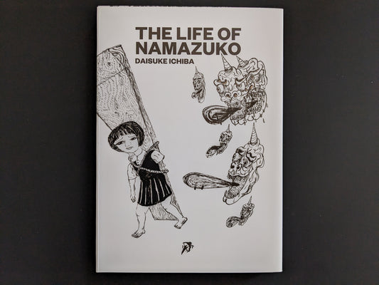 Front cover of The Life of Namazuko by Daisuke Ichiba, showing a girl carrying a plank surrounded by surreal demon heads.