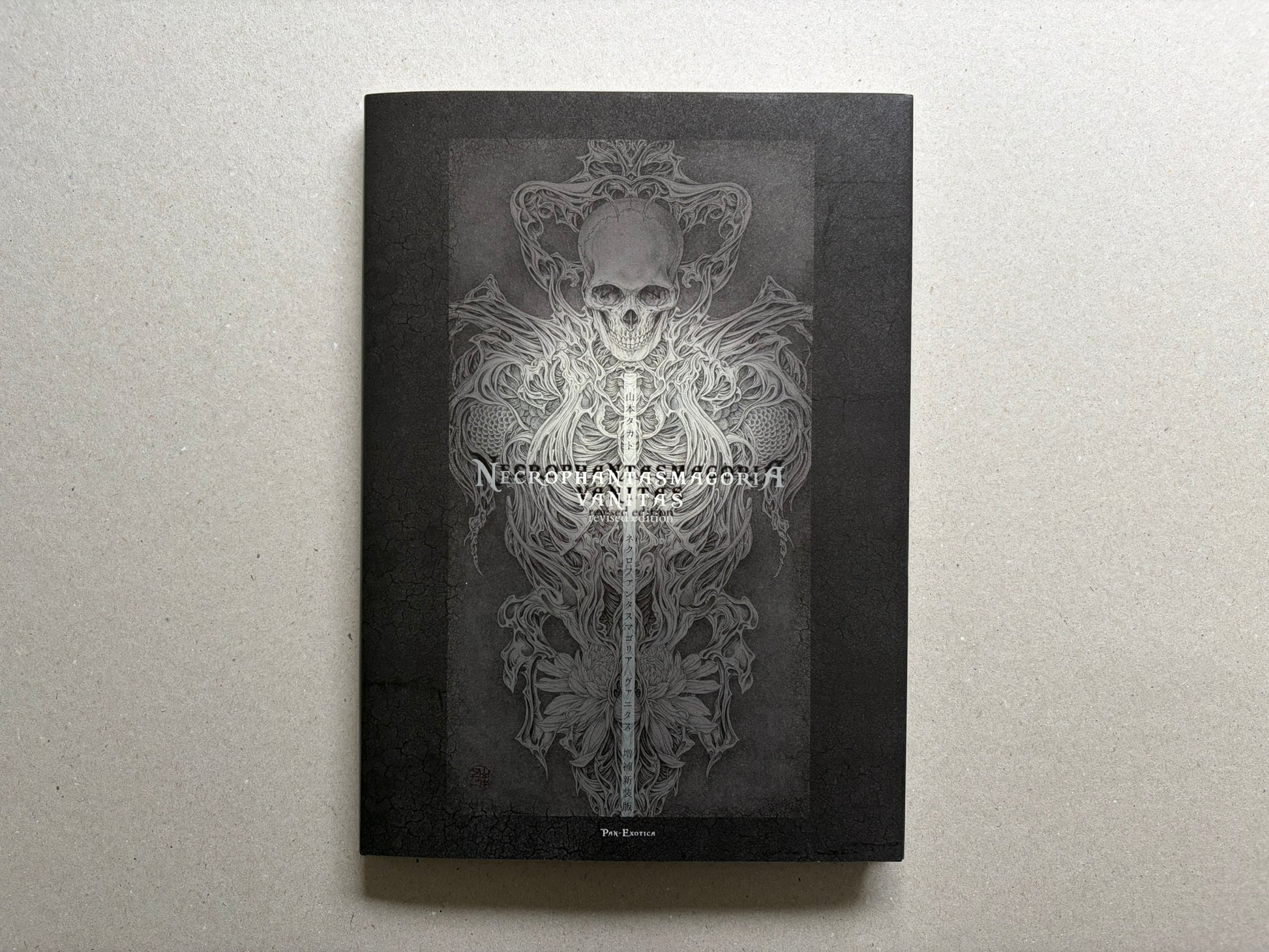 Necrophantasmagoria Vanitas by Takato Yamamoto, front cover with skull and ornamental figure on a black background.