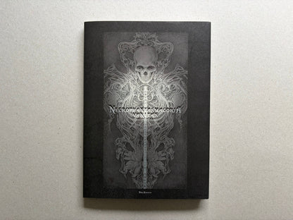 Necrophantasmagoria Vanitas by Takato Yamamoto, front cover with skull and ornamental figure on a black background.