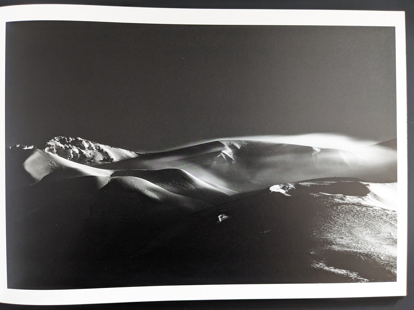Snow forms shaped like dunes in black and white