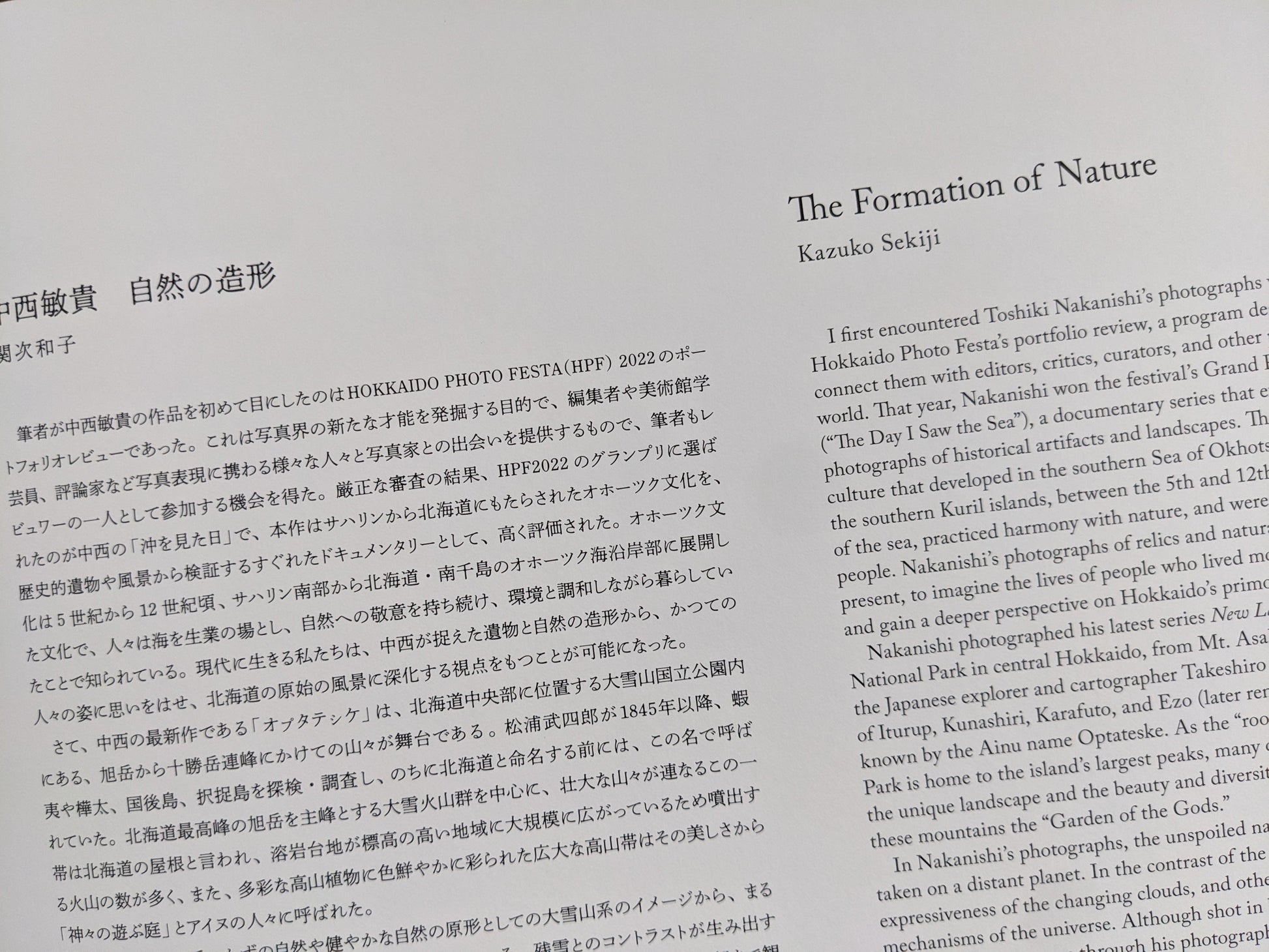 Essay page from New Land – Pre-Hokkaido Landscapes by Toshiki Nakanishi, featuring bilingual text by Kazuko Sekiji