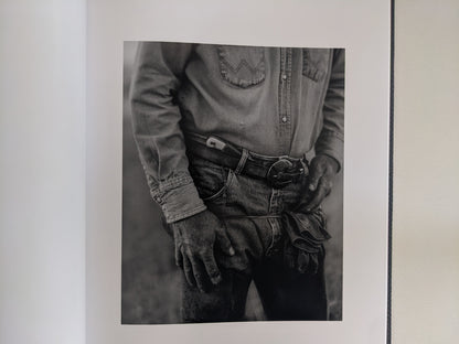 Black-and-white portrait of a rancher’s denim-clad hands and belt in 'No Fences'