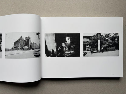 Nobuyoshi Araki, Sentimental Journey 1971–2017, open spread with small black-and-white city and portrait photographs