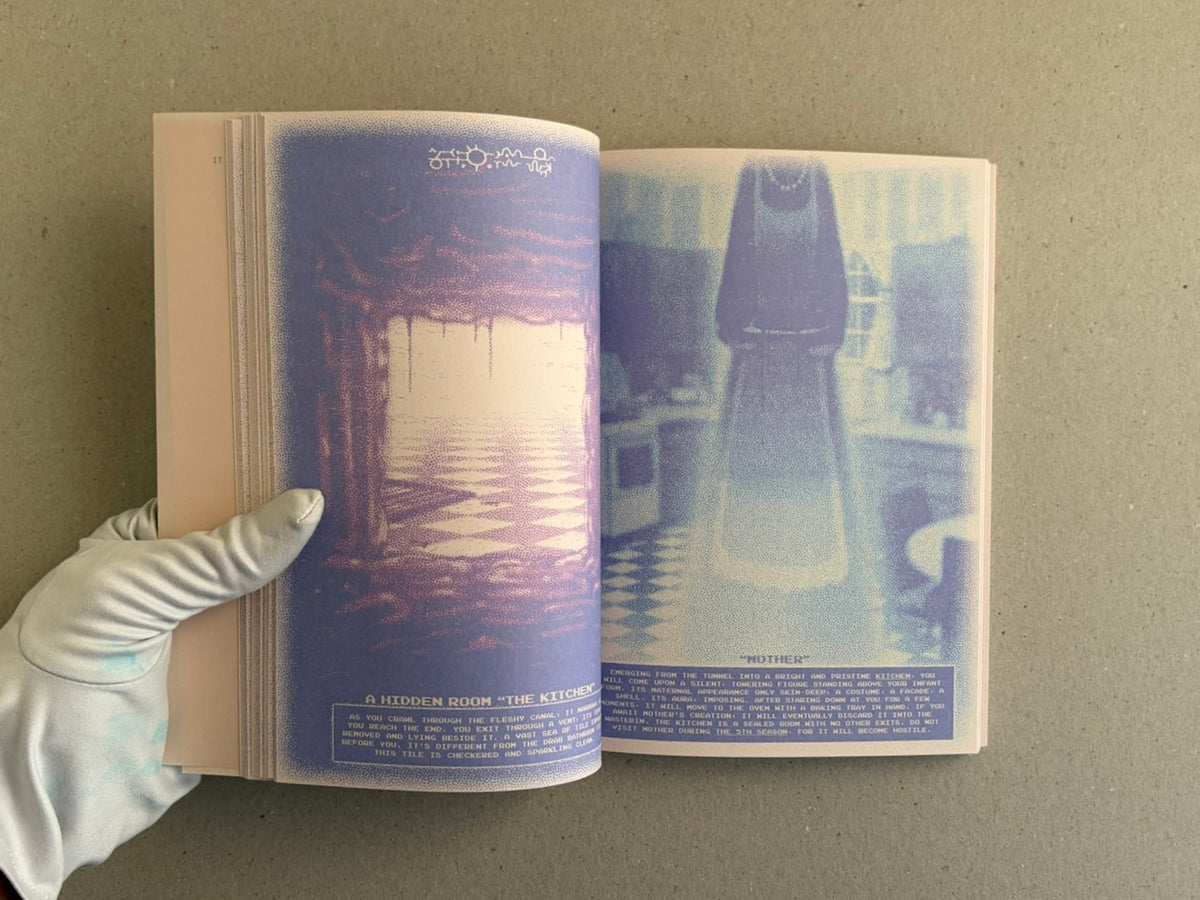Open spread of Nostalgia Nest – The Salamander King, showing two printed pages with blue-toned illustrations and small text at the bottom, held open by a gloved hand.