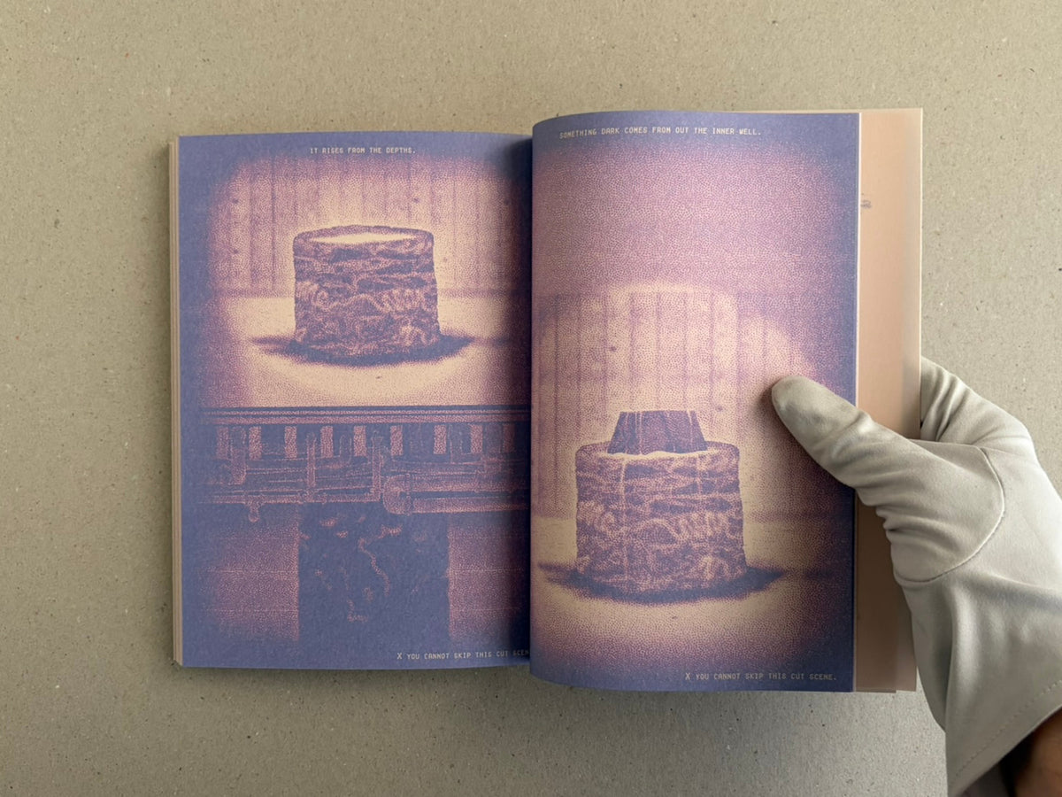 Open spread of Nostalgia Nest – The Salamander King showing two purple-toned illustrated pages with a central stone-like form and a gloved hand holding the book open.