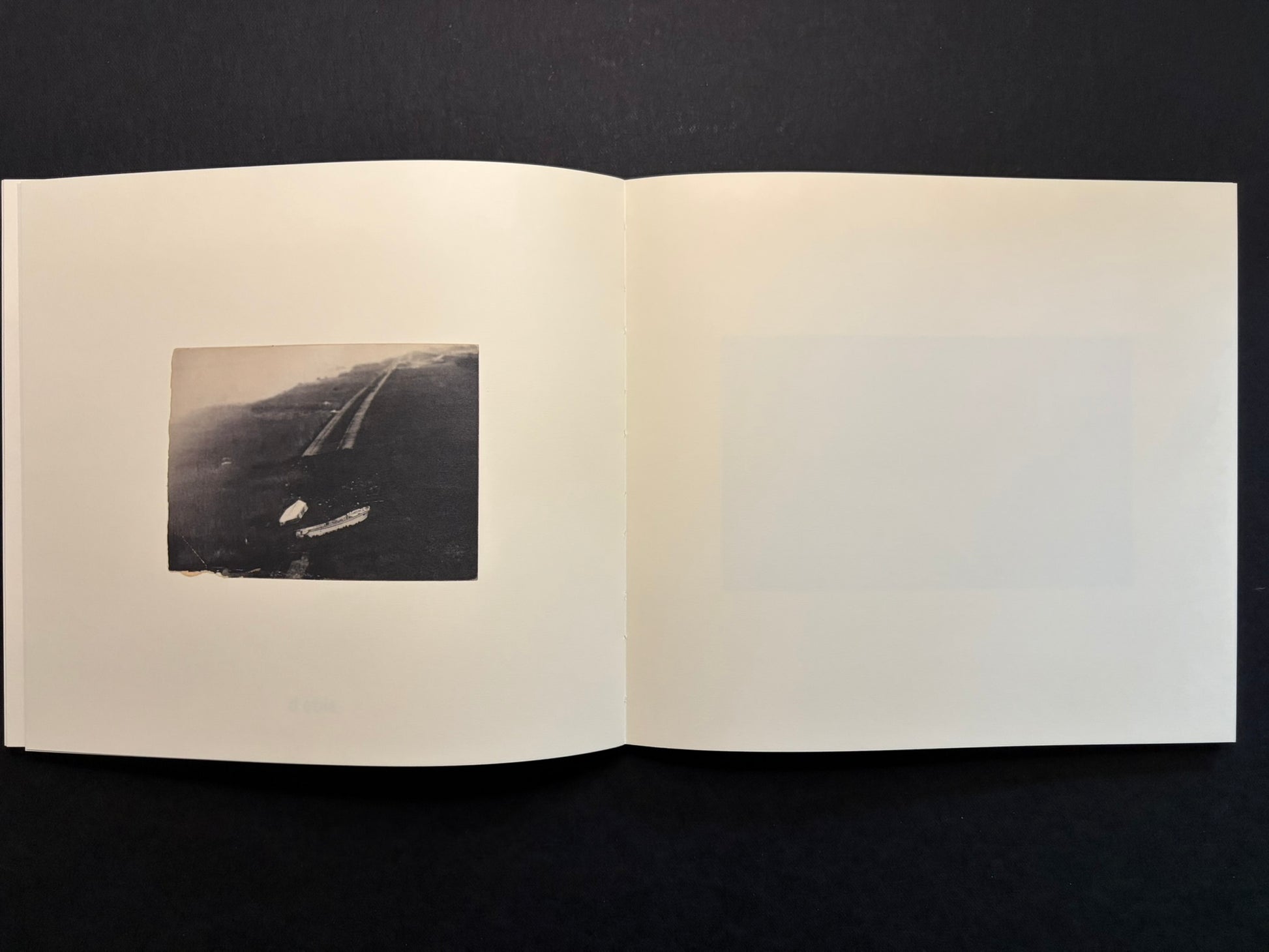 Open Nusa spread with a small dark landscape image on the left page