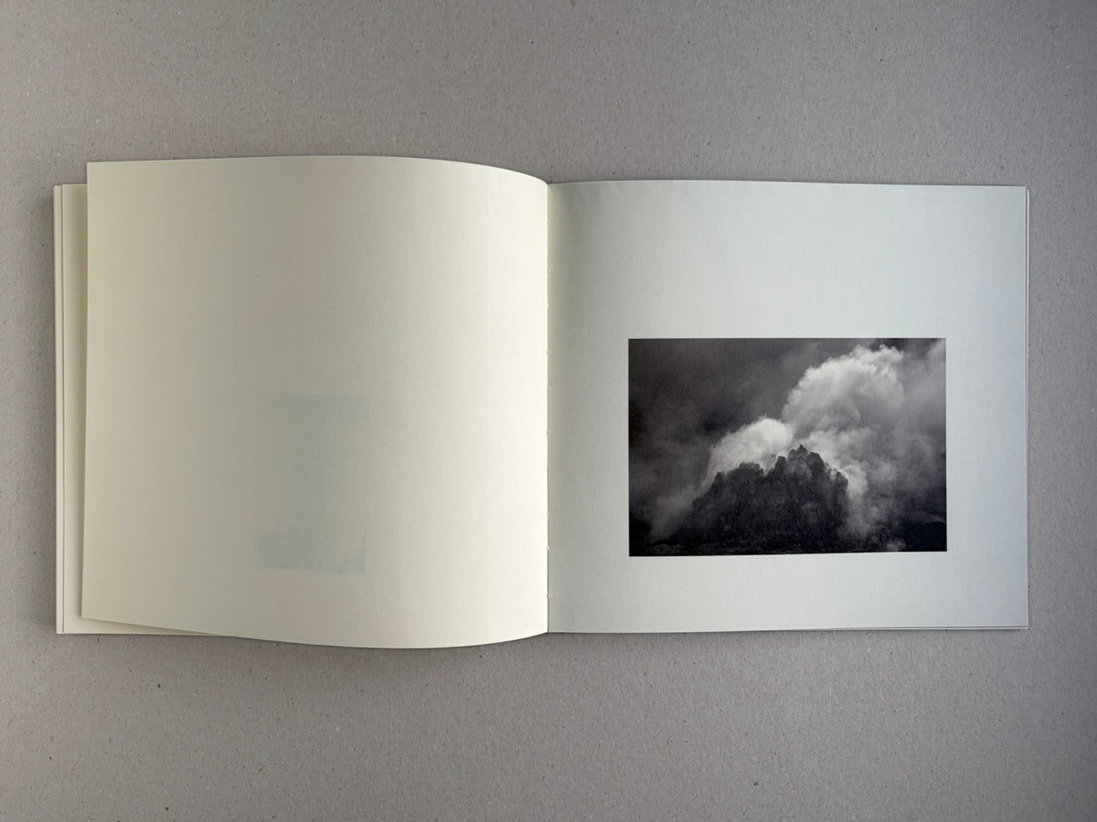 Nusa by Masao Yamamoto, open spread with a cloud over a dark mountain