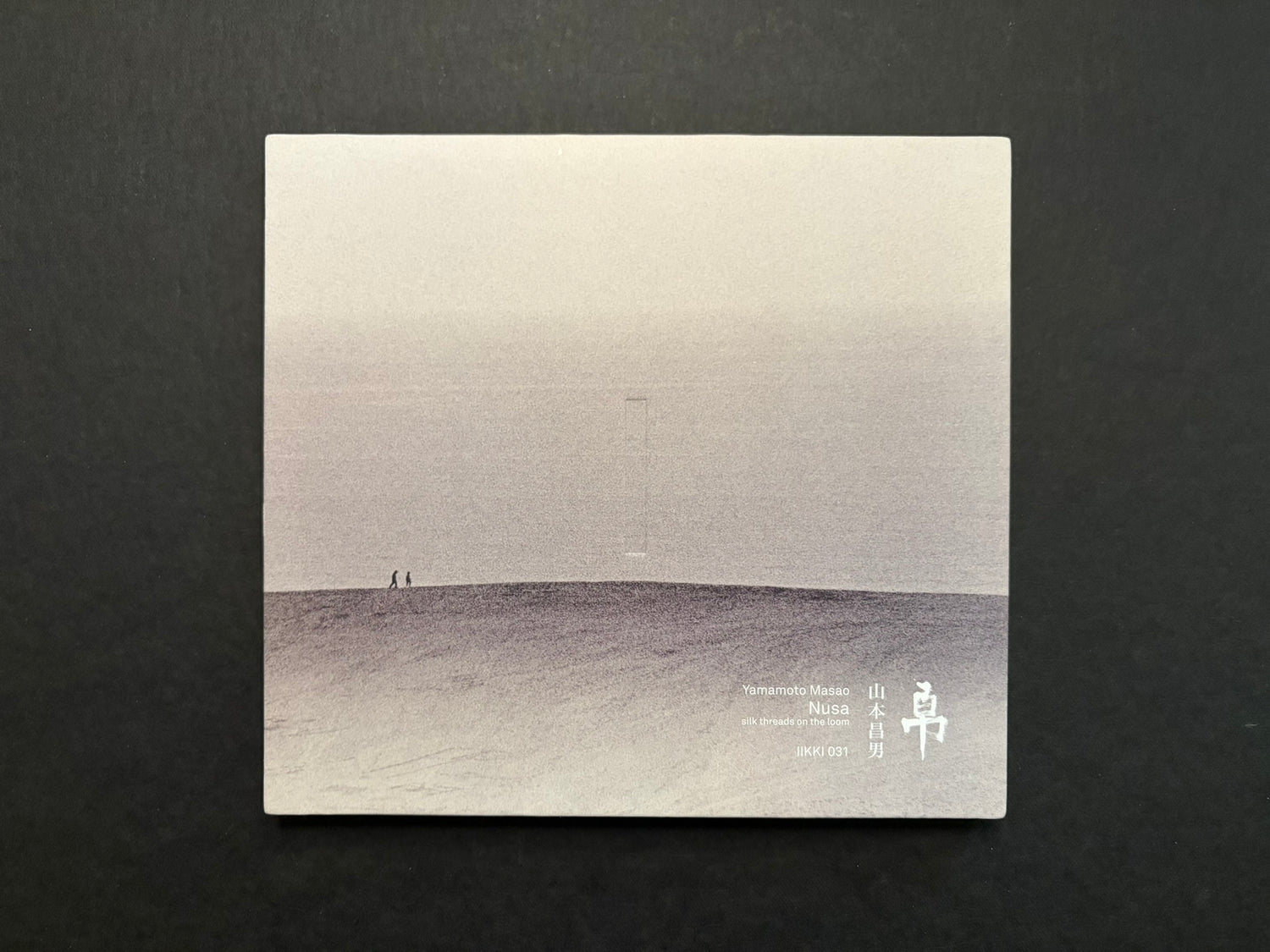 Nusa by Masao Yamamoto, front cover on a dark background