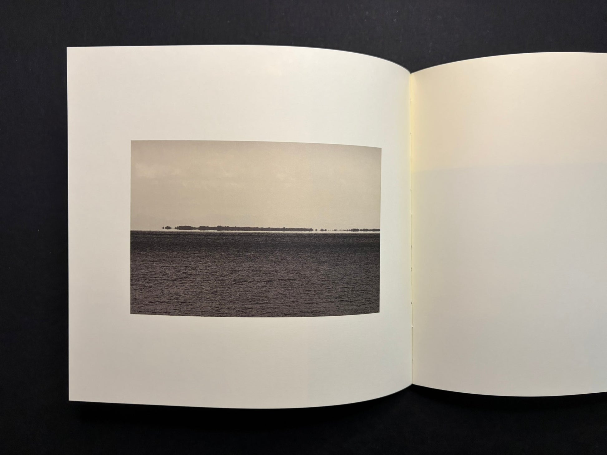 Open Nusa spread with a single landscape photograph on the left page