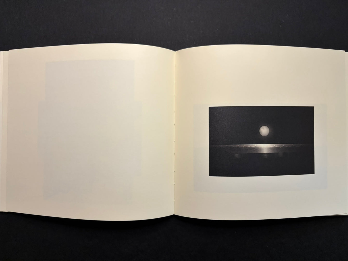 Open Nusa spread with a moon-like circle on the right page