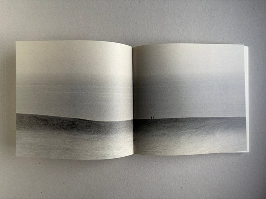 Nusa by Masao Yamamoto, open spread with a wide landscape photograph