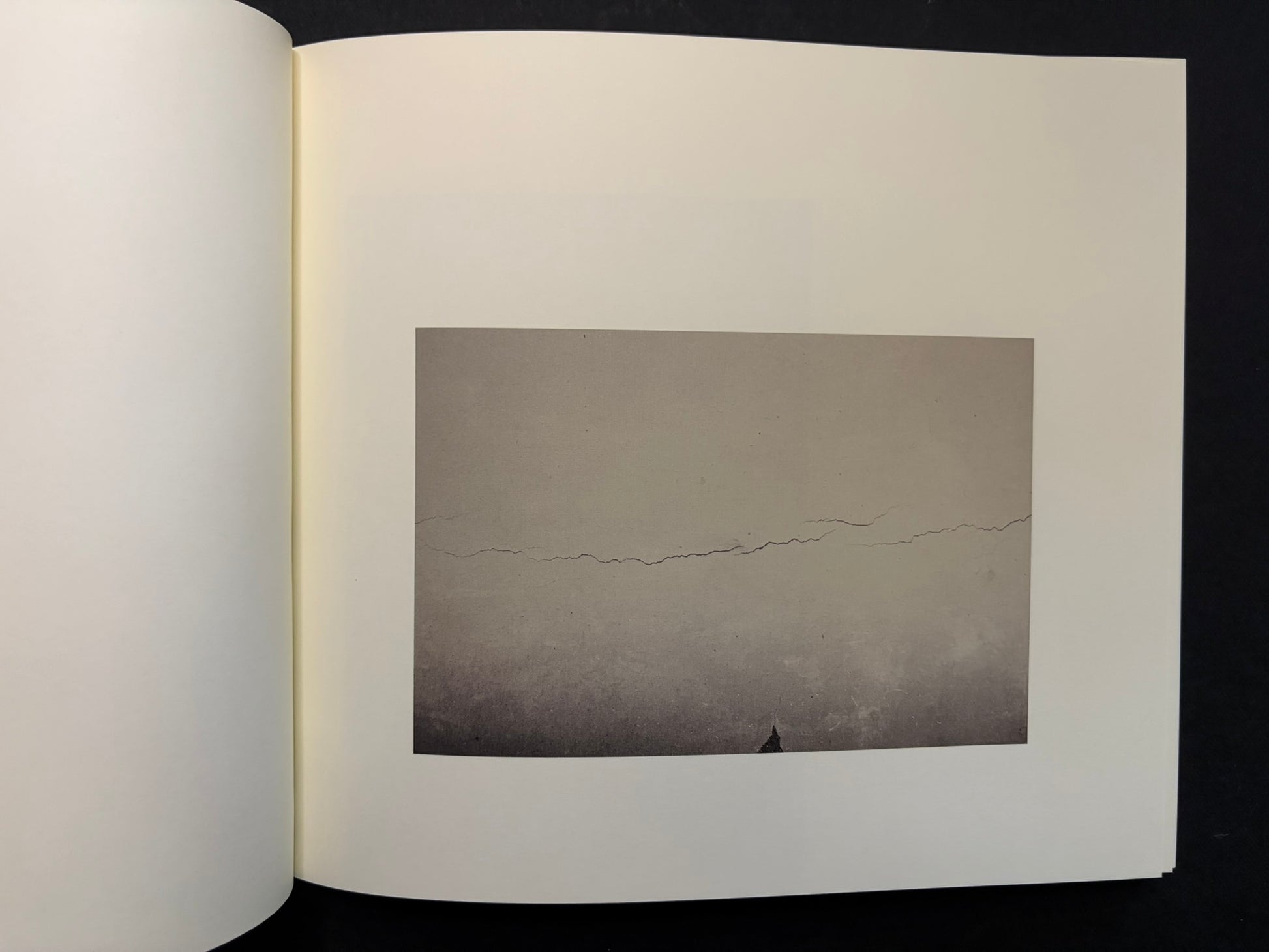 Open Nusa spread with a small landscape photograph on the right page