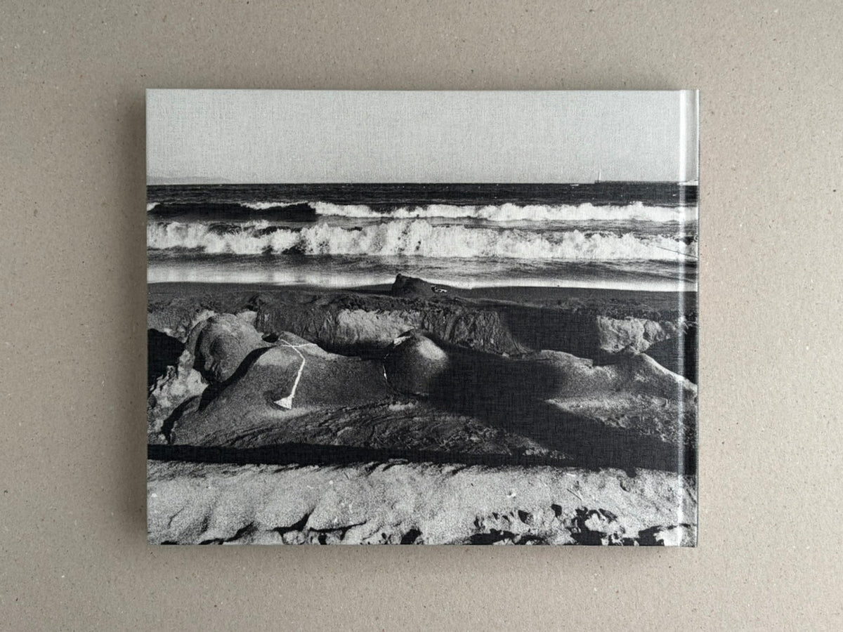 Back cover of Obi and Sand: Kyoto/Enoshima by Yoshio Mizoguchi, showing a black-and-white seascape with waves and sand.