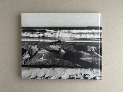 Back cover of Obi and Sand: Kyoto/Enoshima by Yoshio Mizoguchi, showing a black-and-white seascape with waves and sand.