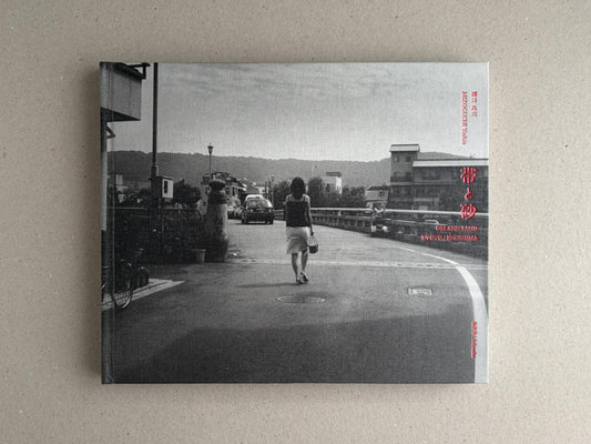 Front cover of Obi and Sand: Kyoto/Enoshima by Yoshio Mizoguchi, showing a black-and-white street scene with a woman walking away on a road and red title text.