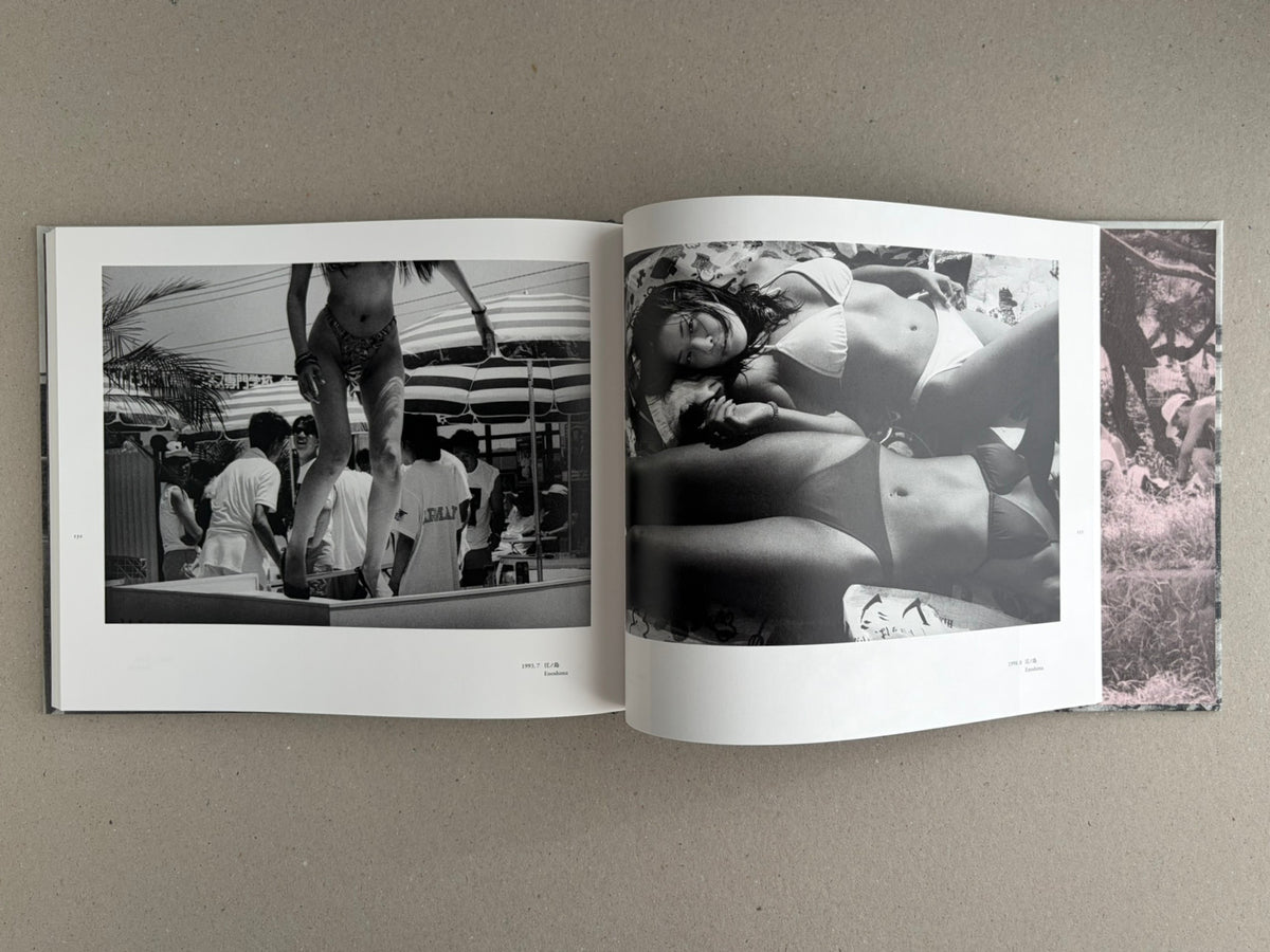 Open photobook spread from Obi and Sand: Kyoto/Enoshima by Yoshio Mizoguchi, showing black-and-white beach photographs and a narrow colour strip at the right edge.