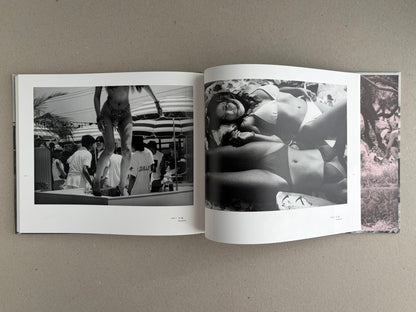 Open photobook spread from Obi and Sand: Kyoto/Enoshima by Yoshio Mizoguchi, showing black-and-white beach photographs and a narrow colour strip at the right edge.