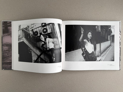 Open photobook spread from Obi and Sand: Kyoto/Enoshima by Yoshio Mizoguchi, showing two black-and-white street photographs across facing pages.